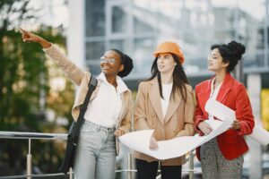 Women leaders discussing construction and engineering plans at a worksite